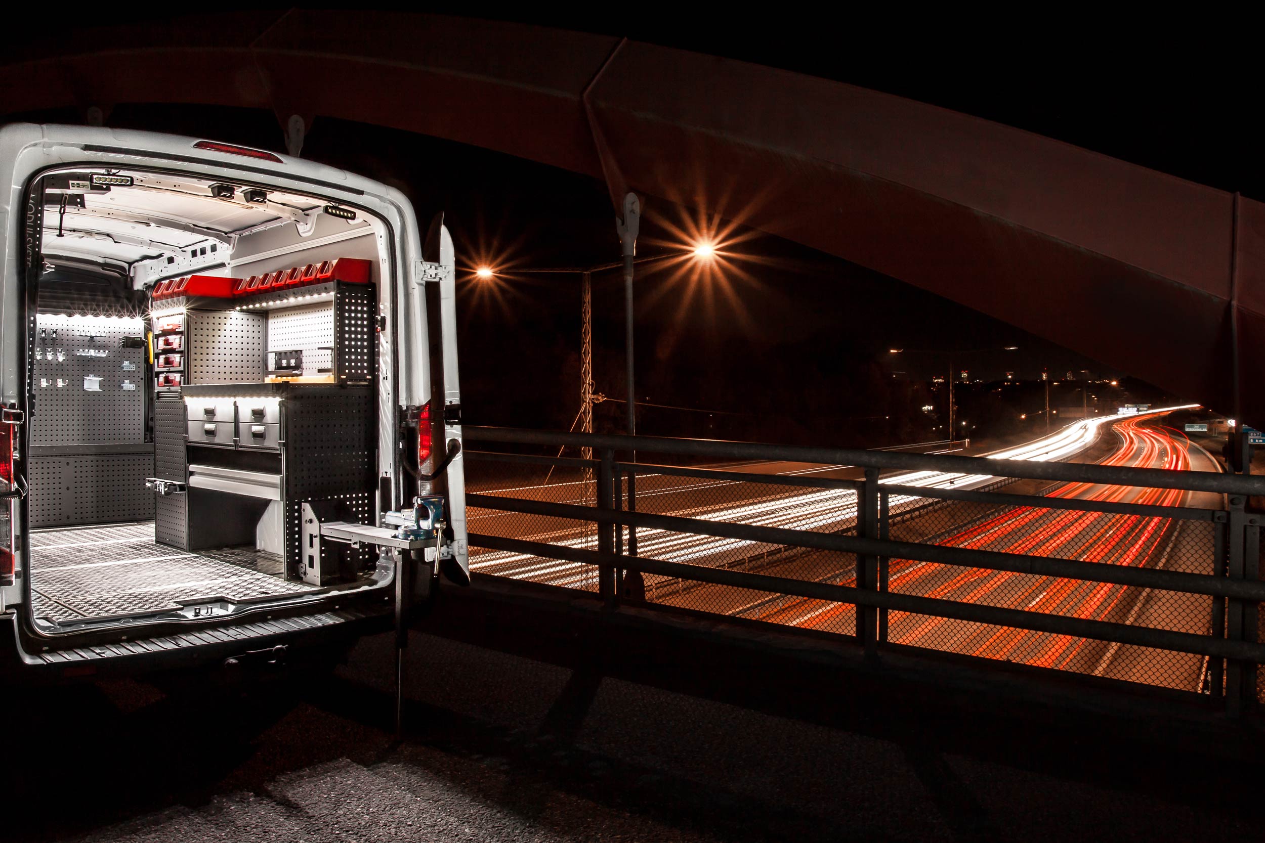 Furgoneta de electricista equipada con un sistema de estanterías Modul-System trabajando por la noche.